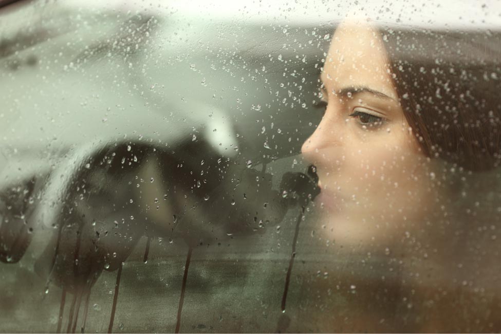 Portrait of a girl by the window right after a rainfall