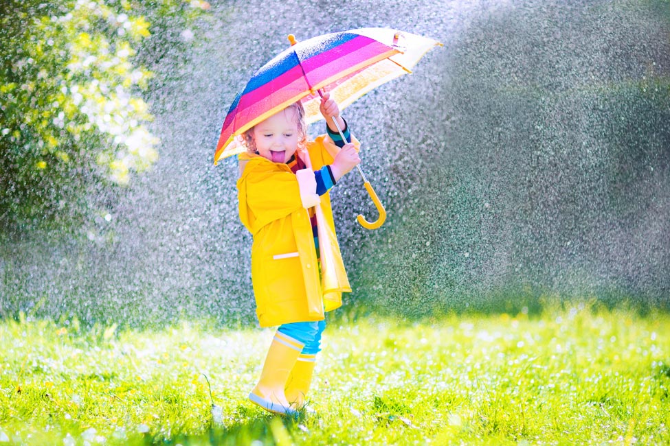 Child holding an umbrella in the rain