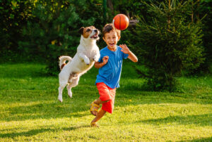 Little boy and his dog playing in their backyard