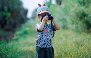 boy taking a photograph in the outdoors
