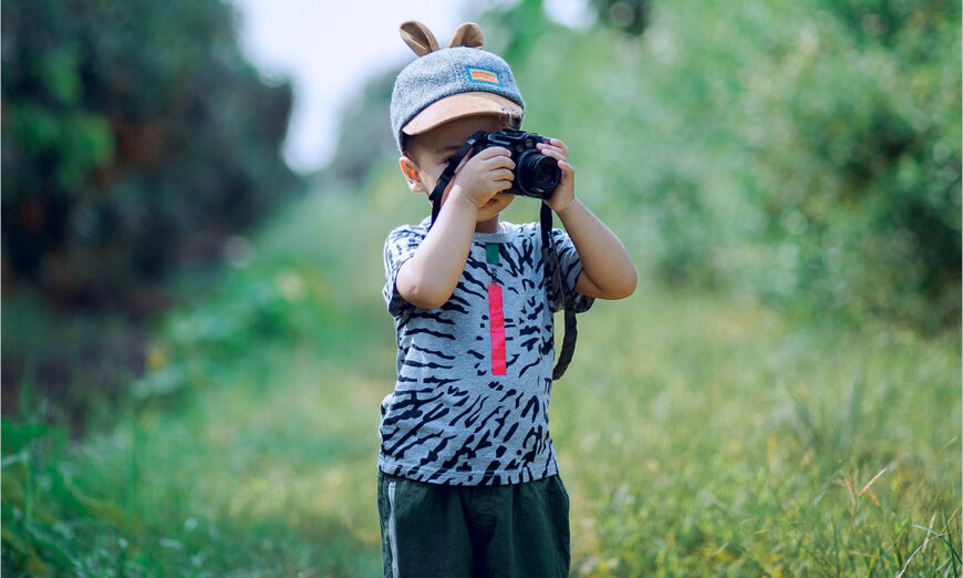 boy taking a photograph in the outdoors