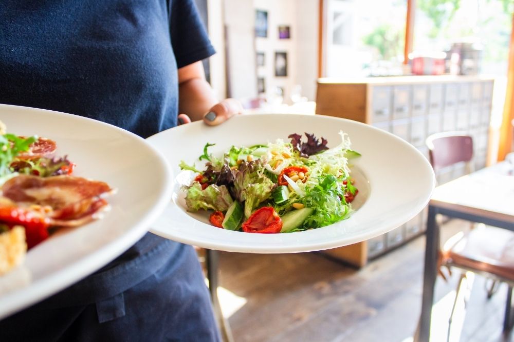Person Carrying Two Plates of Food
