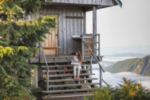 Photo of girl having coffee on the steps of an alpine hut