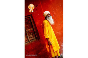 Elderly man standing by a red wall